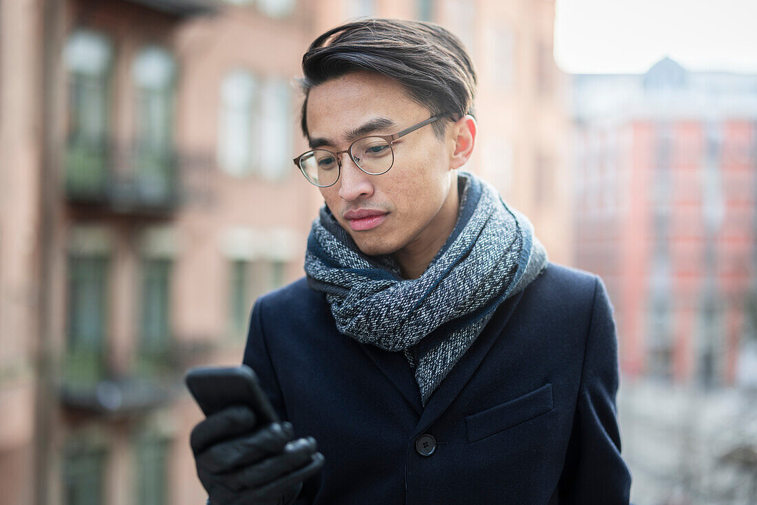 Schöner Mann mit Smartphone auf der Straße