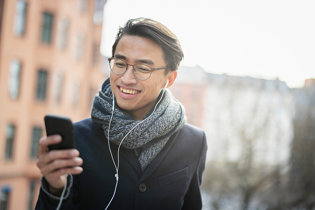 Schöner Mann mit Smartphone auf der Straße