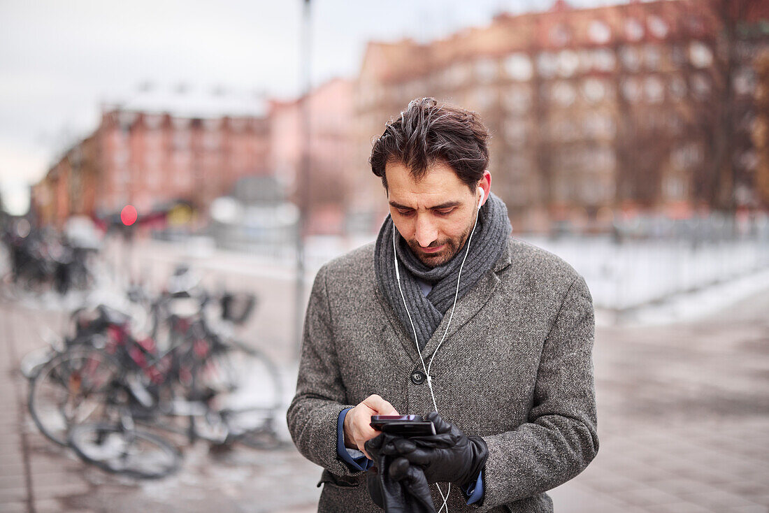 Elegant man with smartphone on street