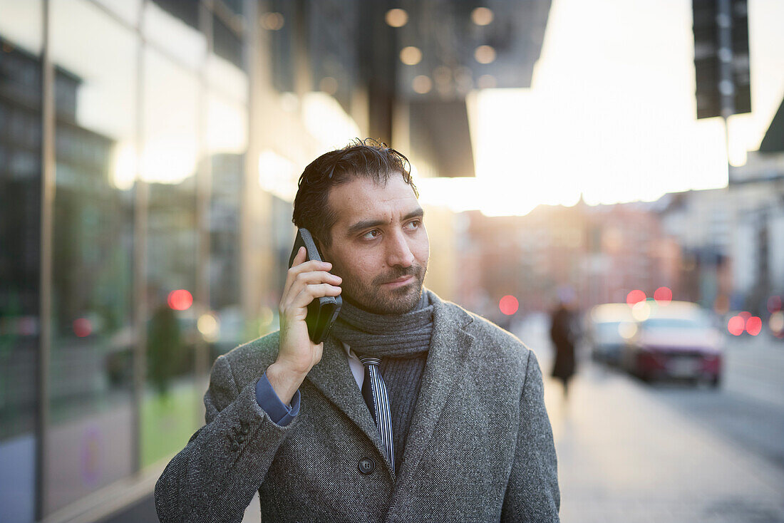 Businessman talking on phone outdoors