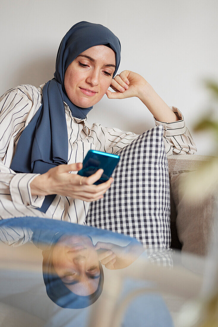 Woman on sofa using cell phone