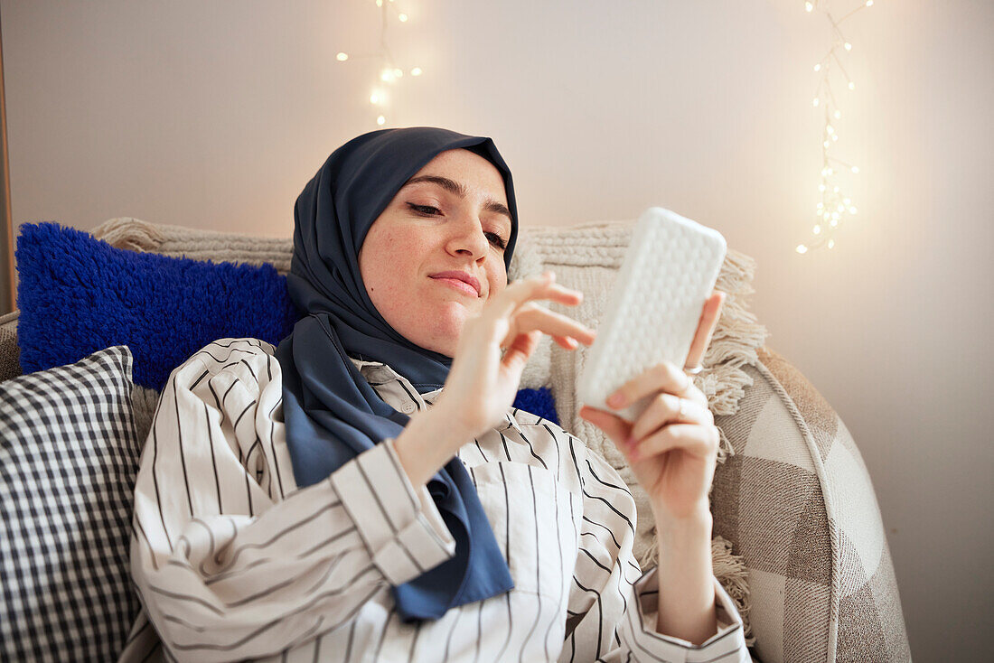 Woman on sofa using cell phone