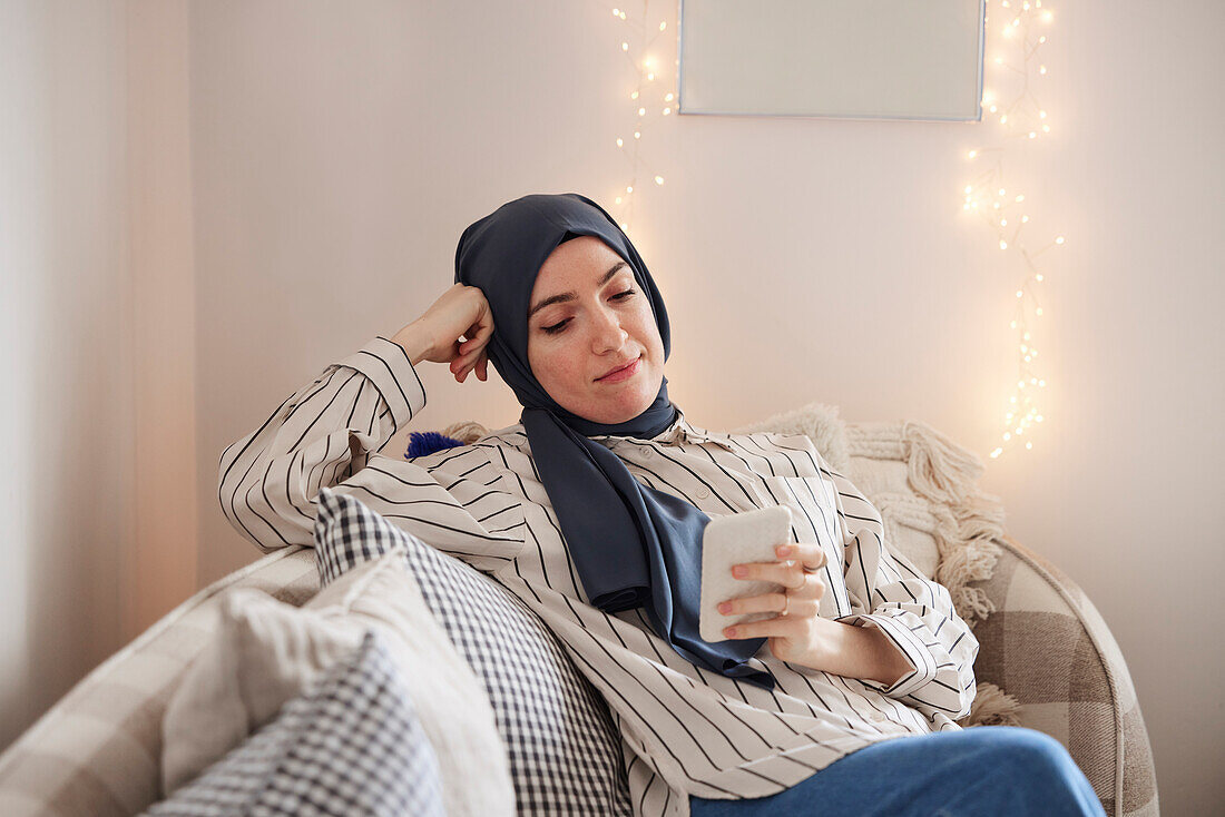 Woman on sofa using cell phone