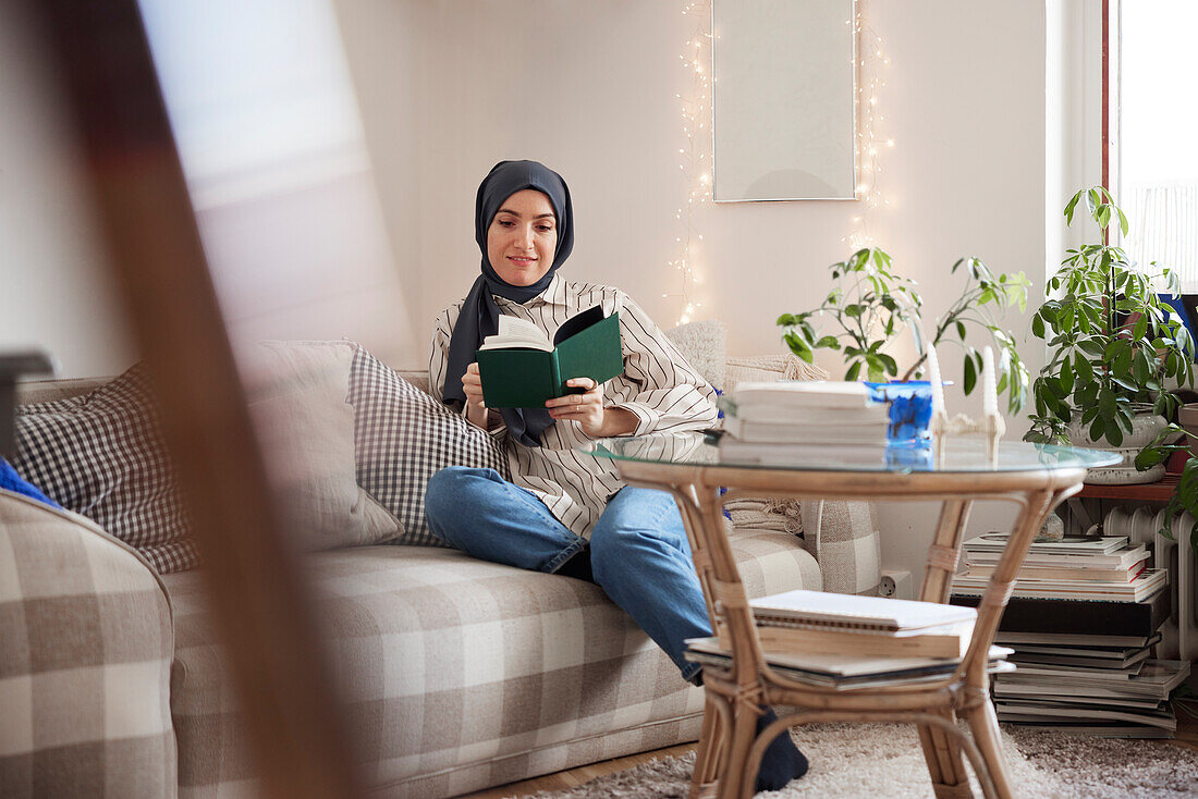 Woman reading on sofa in living room