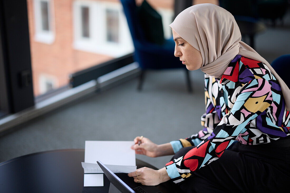 Geschäftsfrau im Hidschab bei der Arbeit im Büro