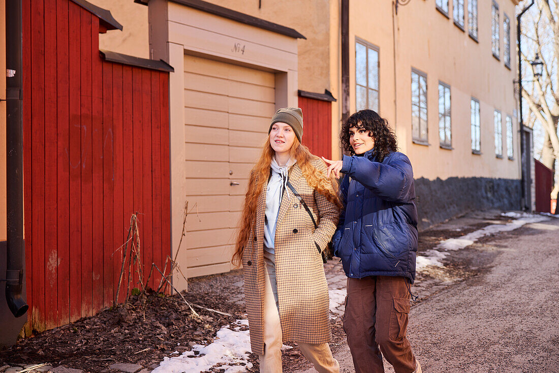 Lächelnde junge Frauen beim Spaziergang auf der Straße