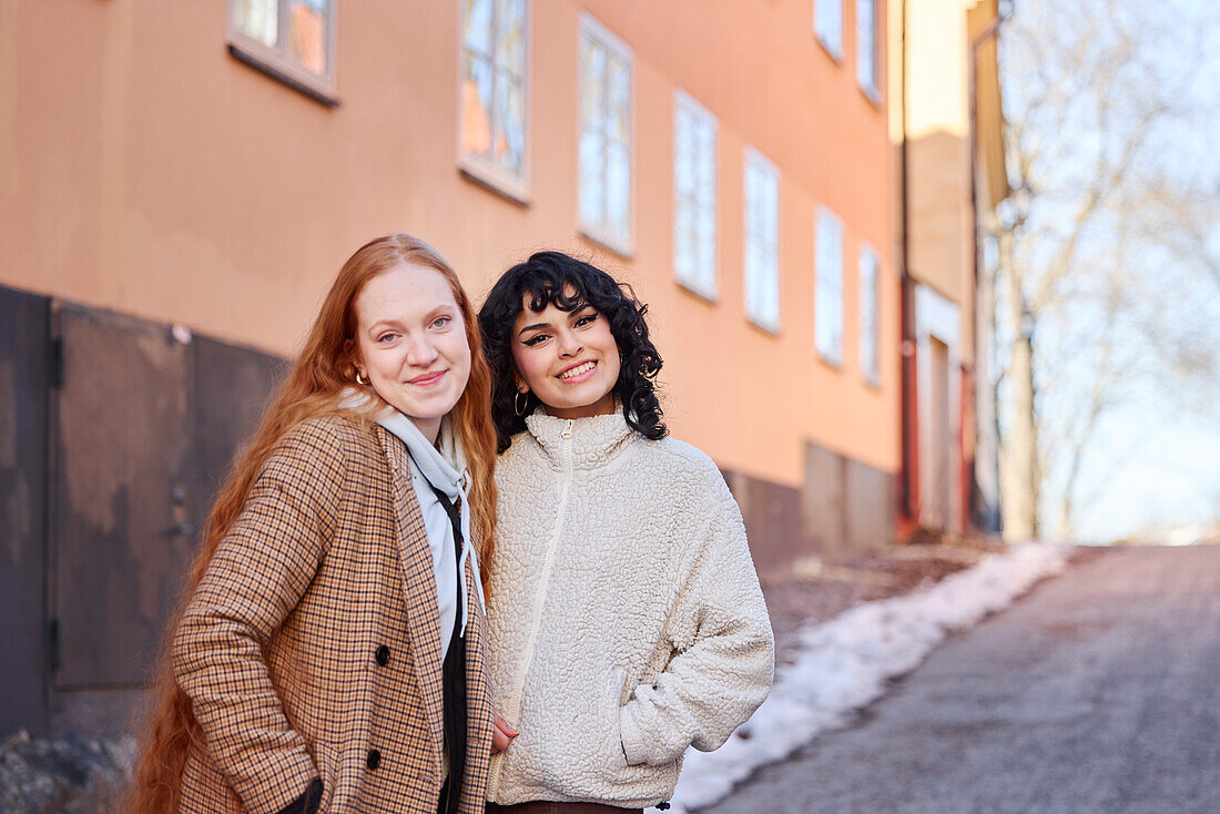 Portrait of smiling young women in street