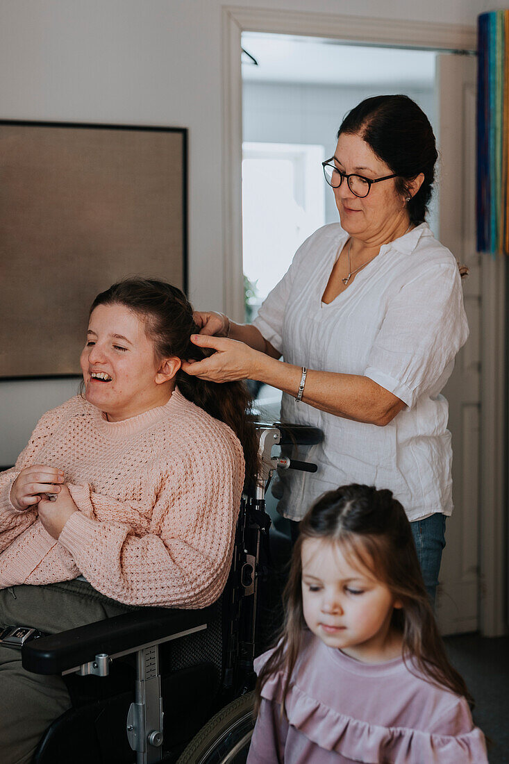 Mutter flechtet der Tochter die Haare