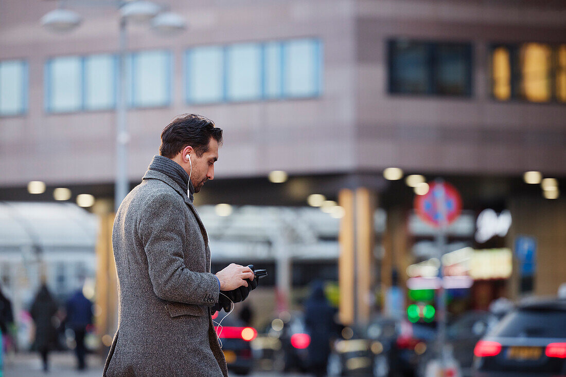 Businessman using phone outdoors in city