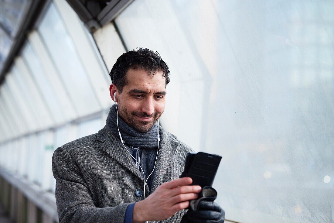 Businessman using phone outdoors in city