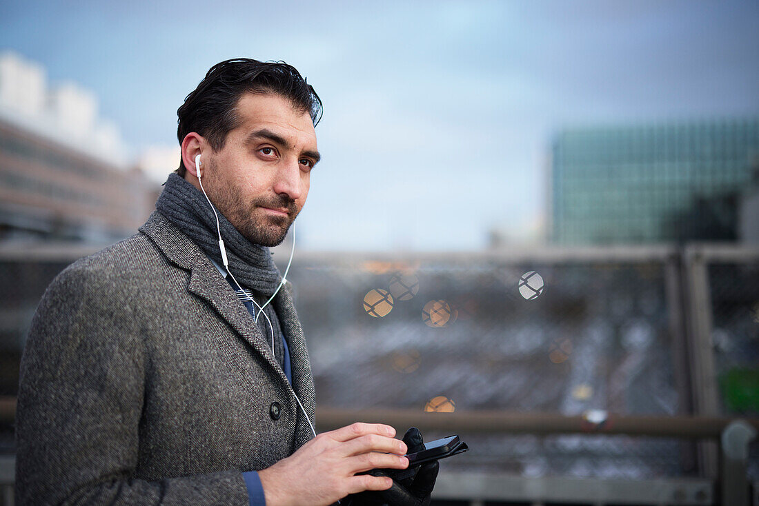 Businessman using phone outdoors in city