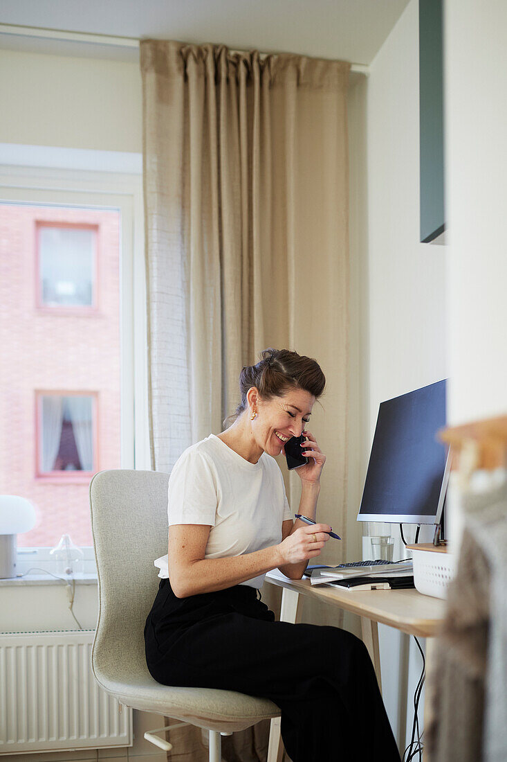 Woman at desk using cell phone
