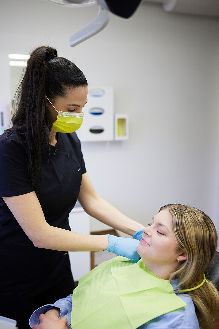 Female dentist with patient in office