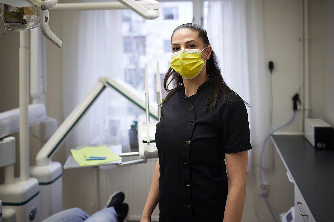 Female dentist standing in office