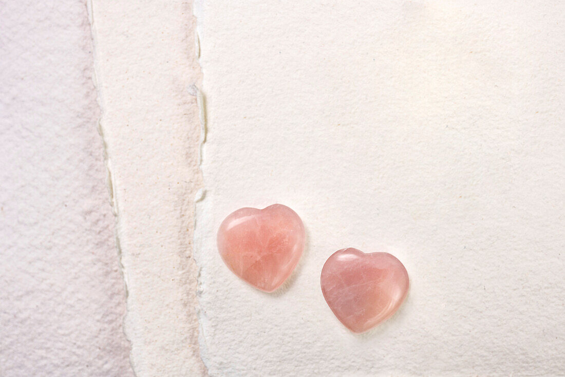 Glass hearts on white paper