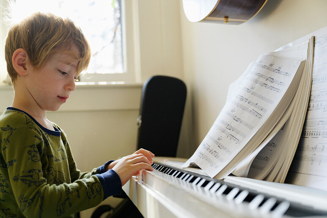 Boy (6-7) playing piano