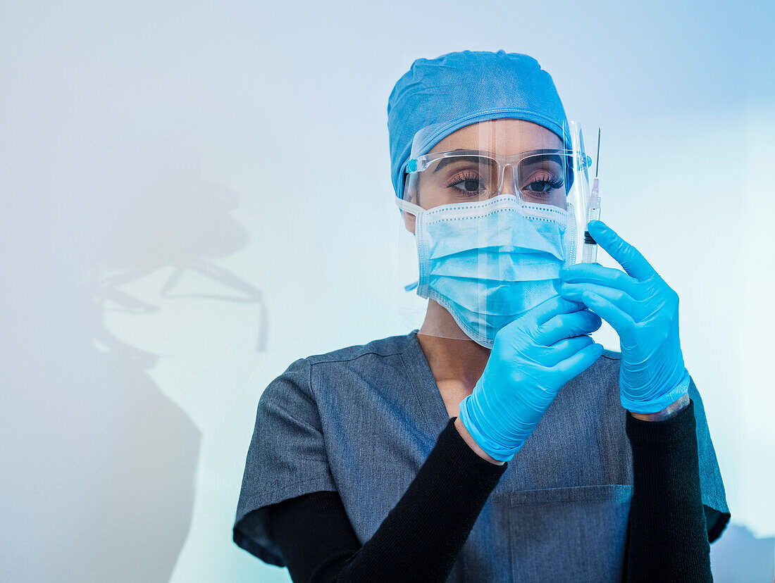 Nurse in face mask and shield preparing Covid-19 vaccination