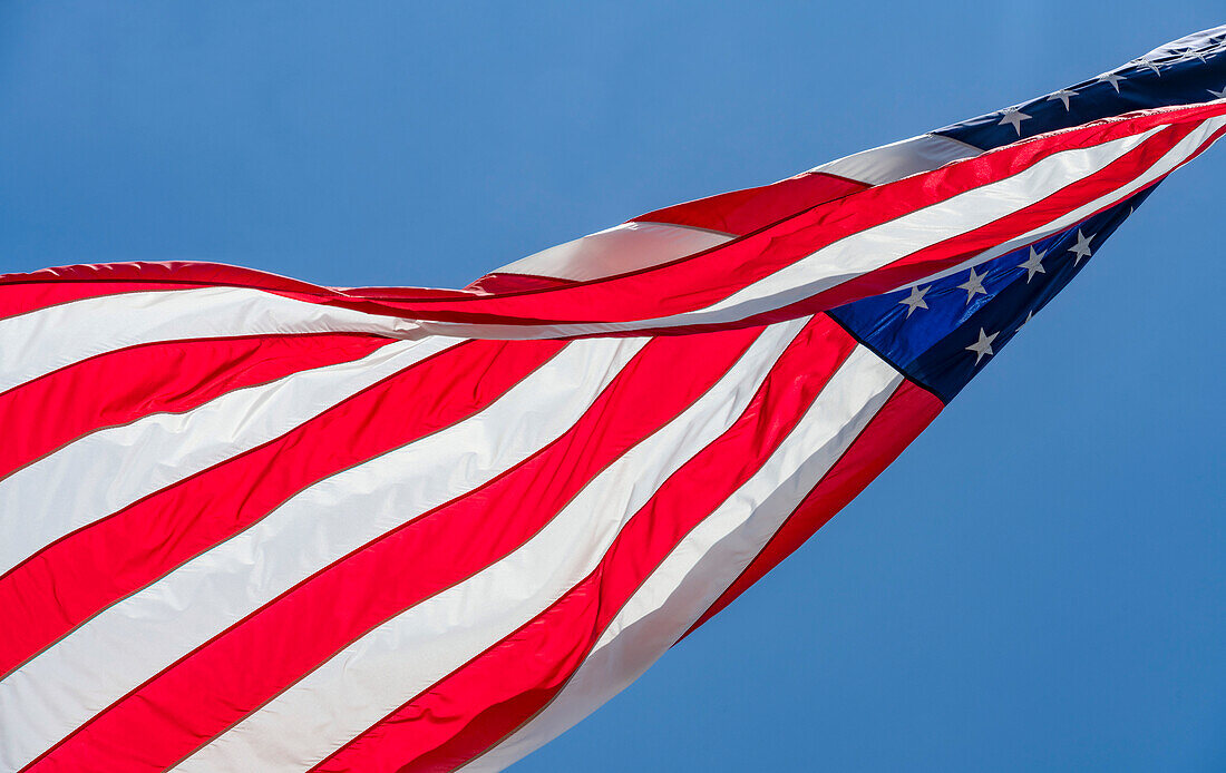 Niedriger Winkel der amerikanischen Flagge im Wind gegen den klaren Himmel