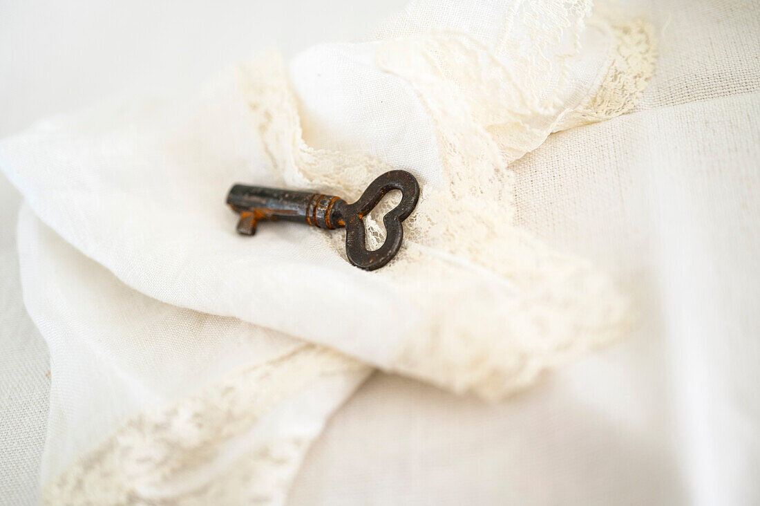 Herzförmiger Schlüssel auf dekorativem weißem Tuch
