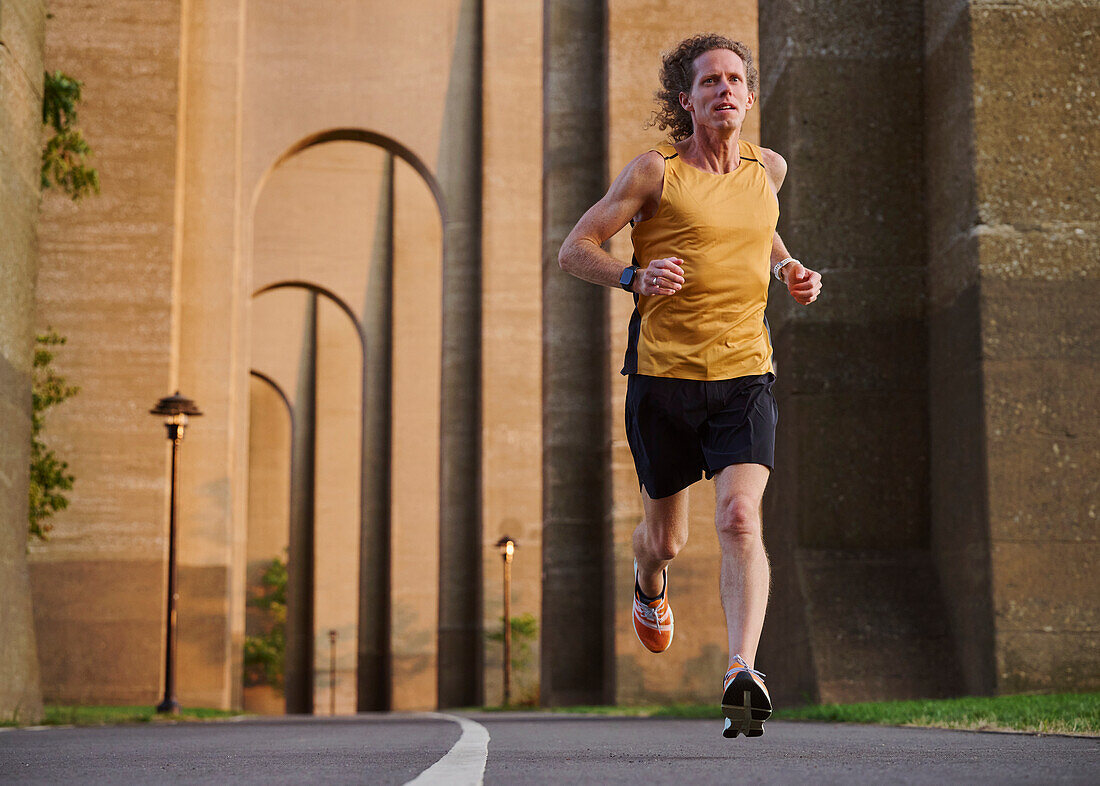 Man jogging under bridge