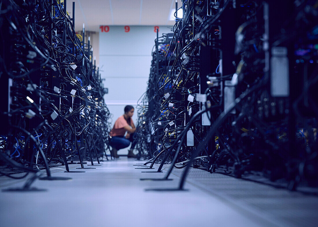 Female technician working in server room