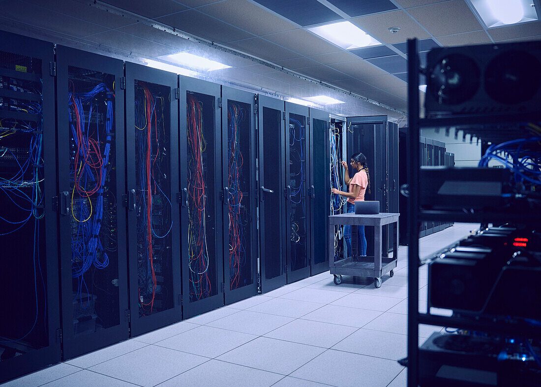 Female technician working in server room