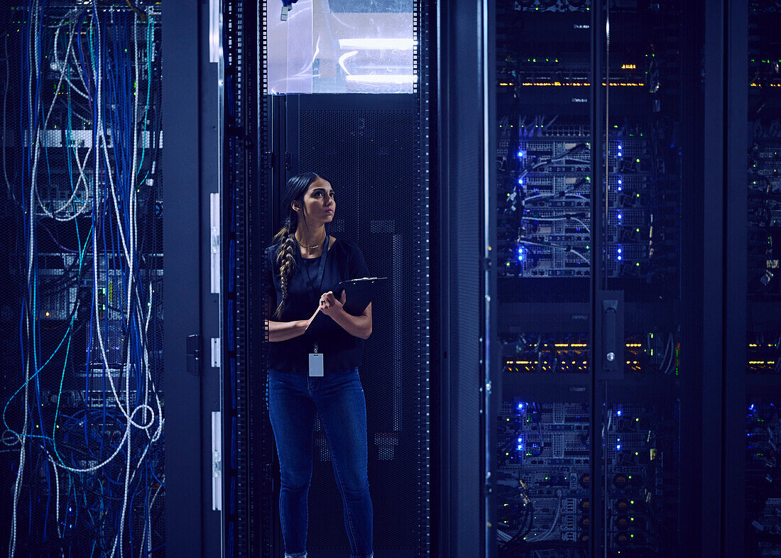 Female technician working in server room