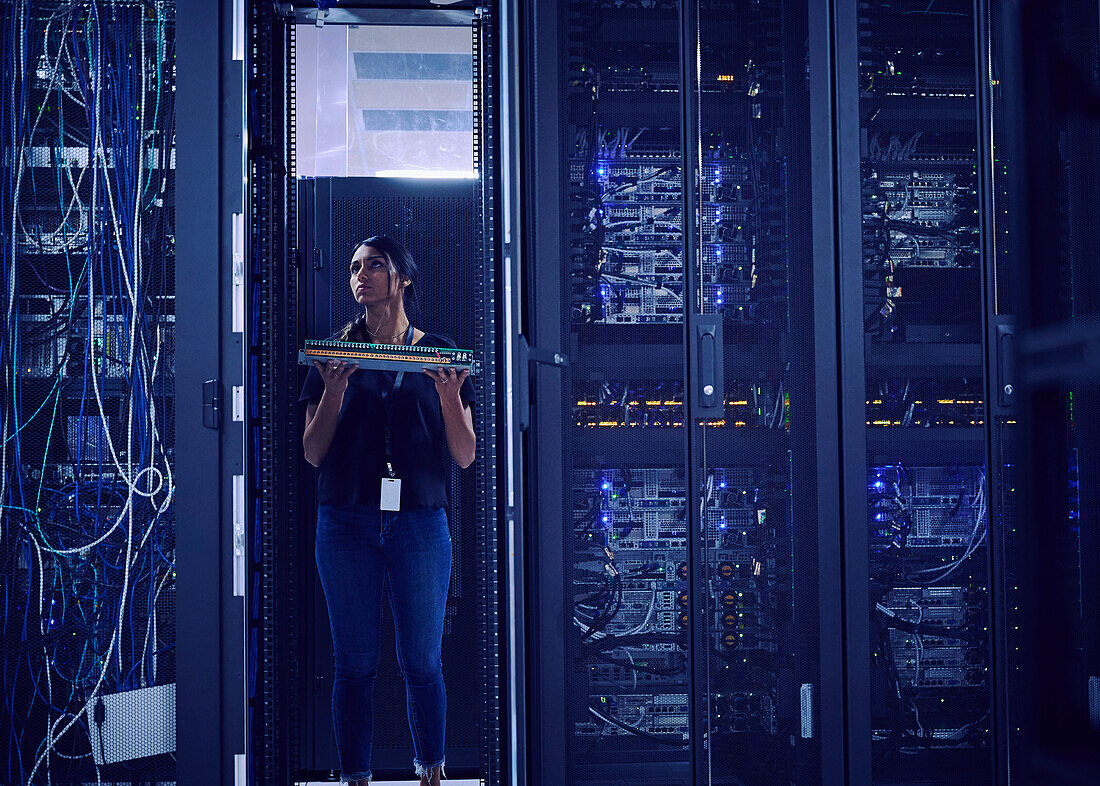 Female technician working in server room