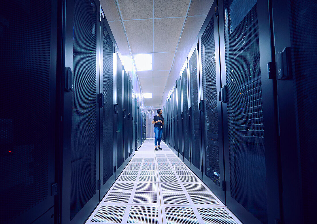 Female technician working in server room