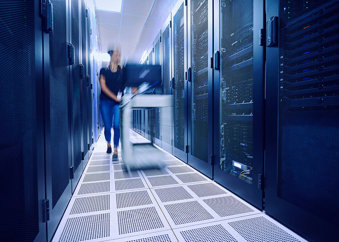 Female technician pushing cart in server room