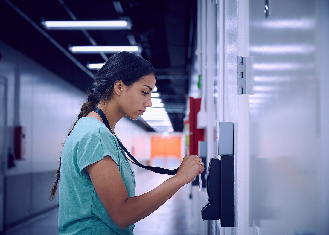 Woman using security card to enter room in data center