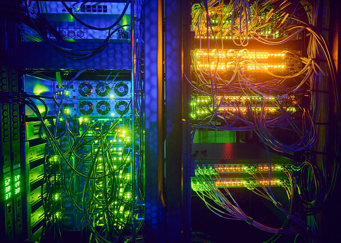 Illuminated servers and computer cables in server room