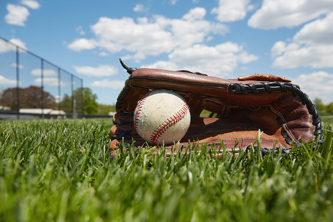 Baseballhandschuh und Ball auf Gras