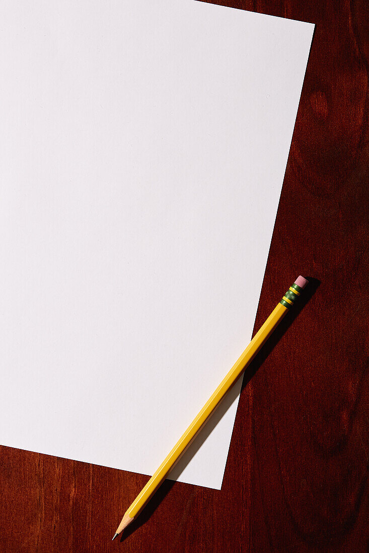 Overhead view of blank paper and pencil on desktop