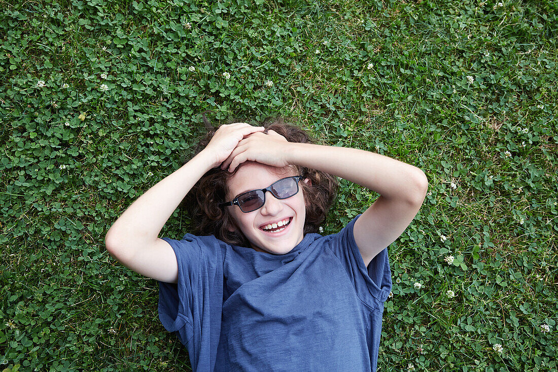 Boy lying in grass and laughing