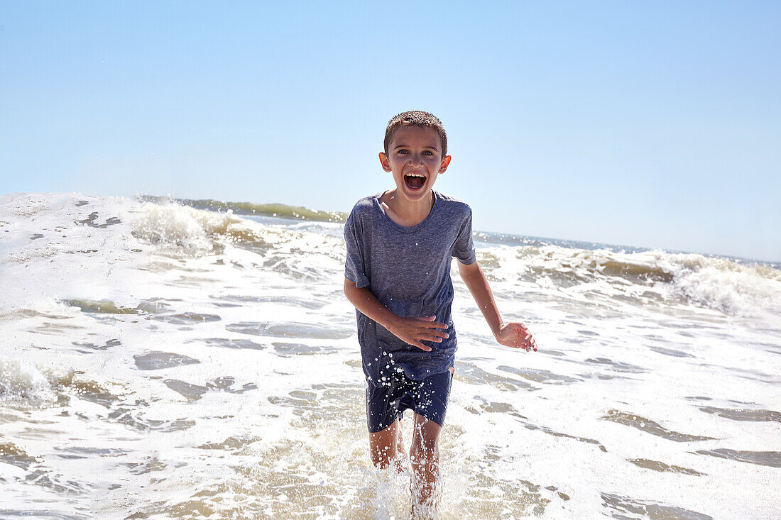 Portrait of smiling boy (8-9) playing in sea waves