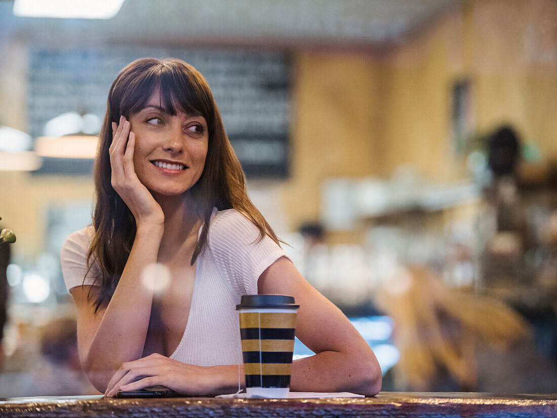 Lächelnde Frau sitzt in einem Cafe