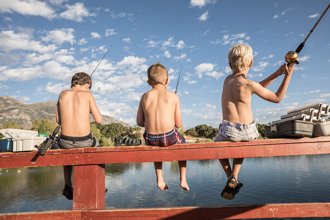 Vereinigte Staaten, Utah, Highland, Rückansicht von hemdlosen Jungen (8-9) beim Angeln am See