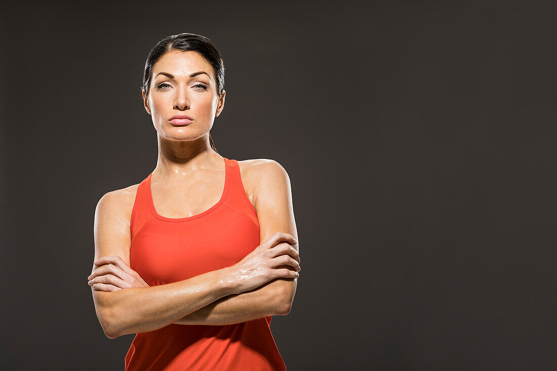 Studioporträt einer sportlichen Frau in rotem ärmellosen Oberteil