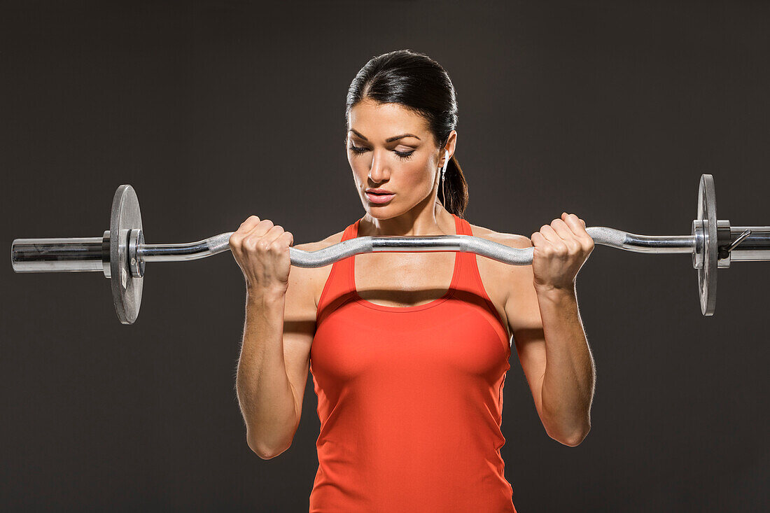 Athletic woman in red sleeveless top weight training