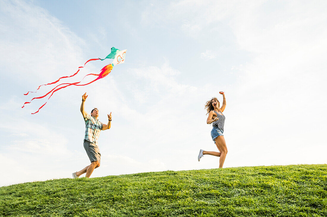 Woman and man flying kite in park 