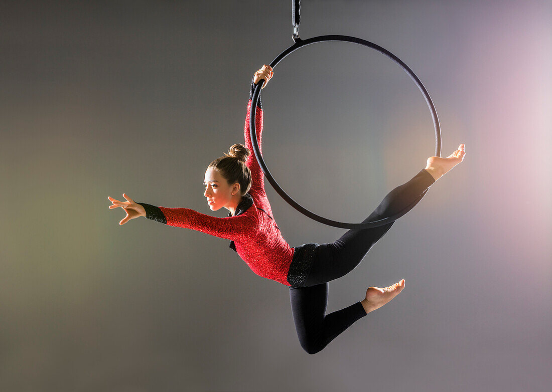 Jugendlicher Luftakrobat (14-15) beim Üben am Gymnastikreifen