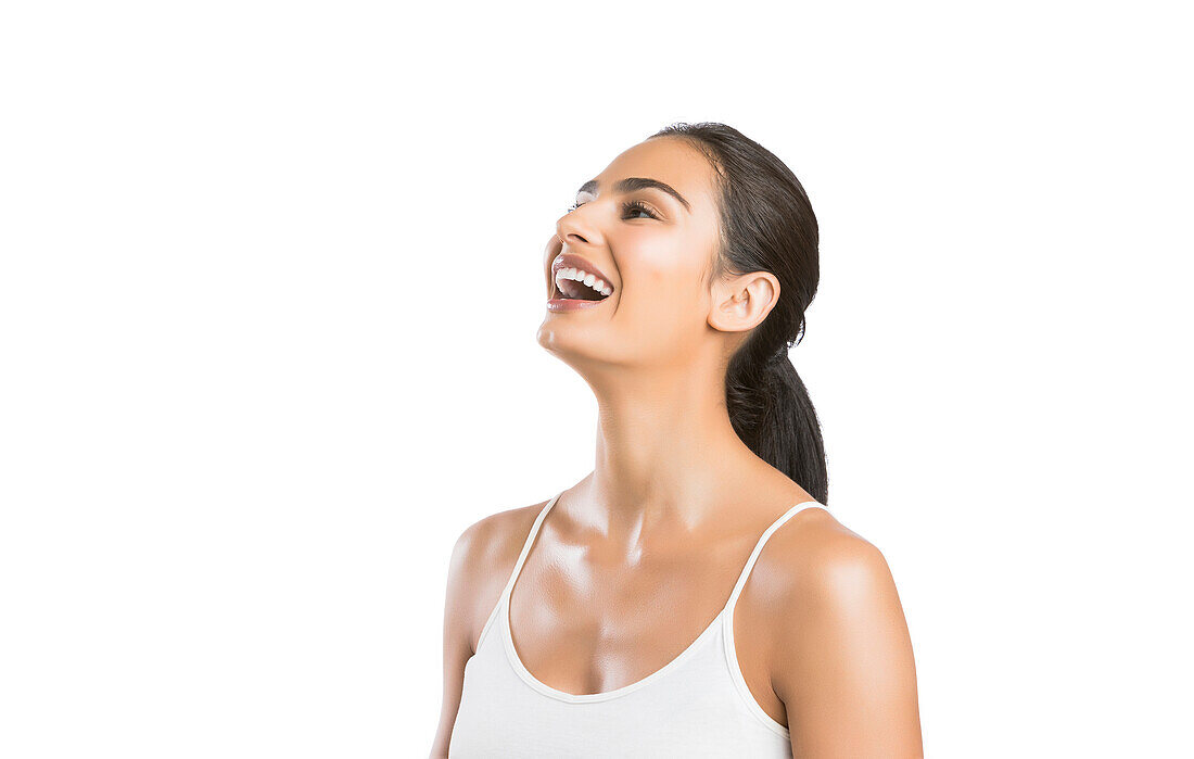 Porträt einer lachenden jungen Frau vor weißem Hintergrund