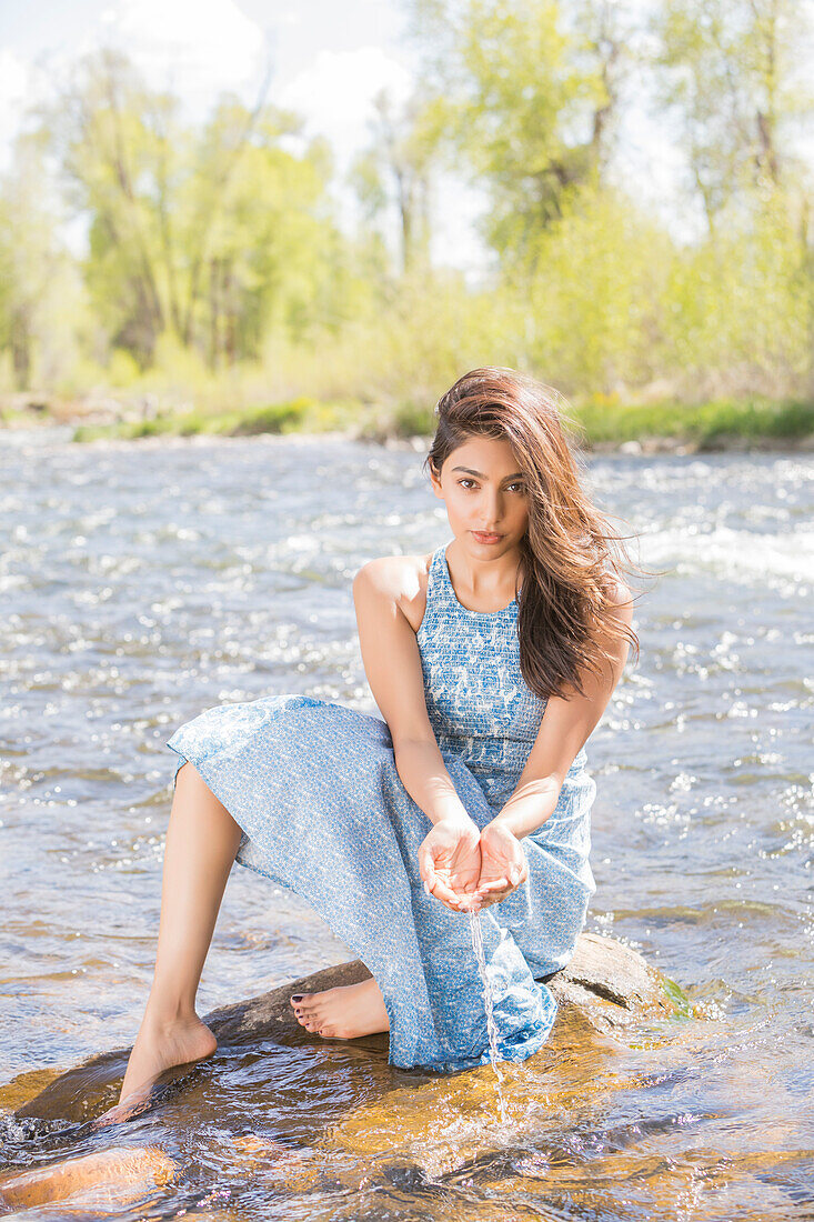 Porträt einer jungen Frau in langem Kleid am Fluss