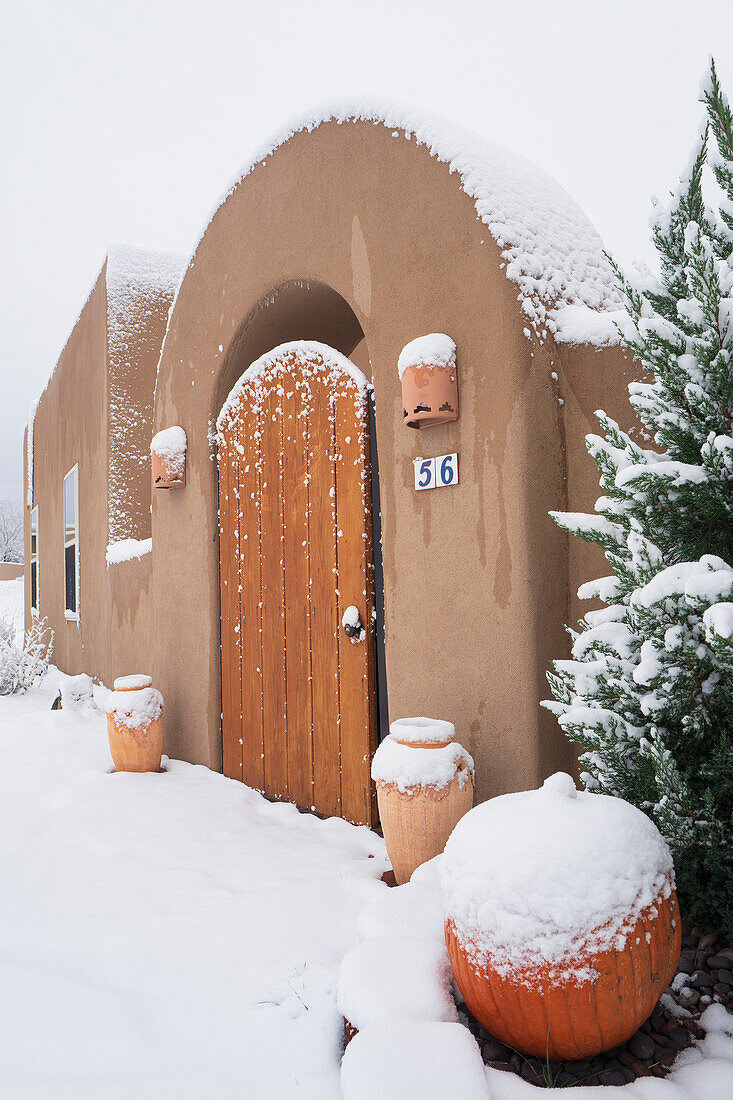 United States, New Mexico, Santa Fe, Autumn snow at front of Pueblo style home 