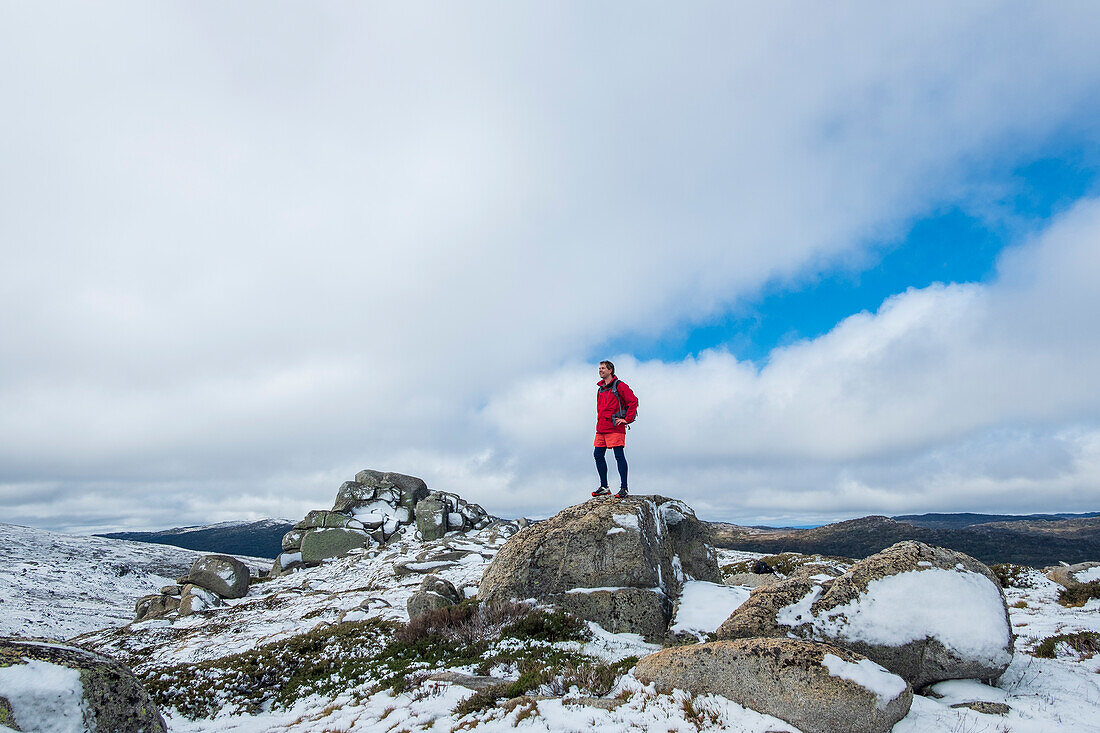 Australien, Neusüdwales, Mann steht auf einem Felsen am Charlotte Pass im Kosciuszko-Nationalpark