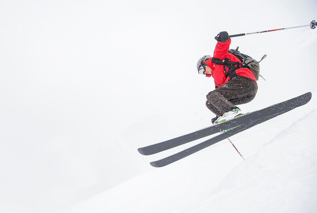 Skifahrer springt auf verschneiter Piste