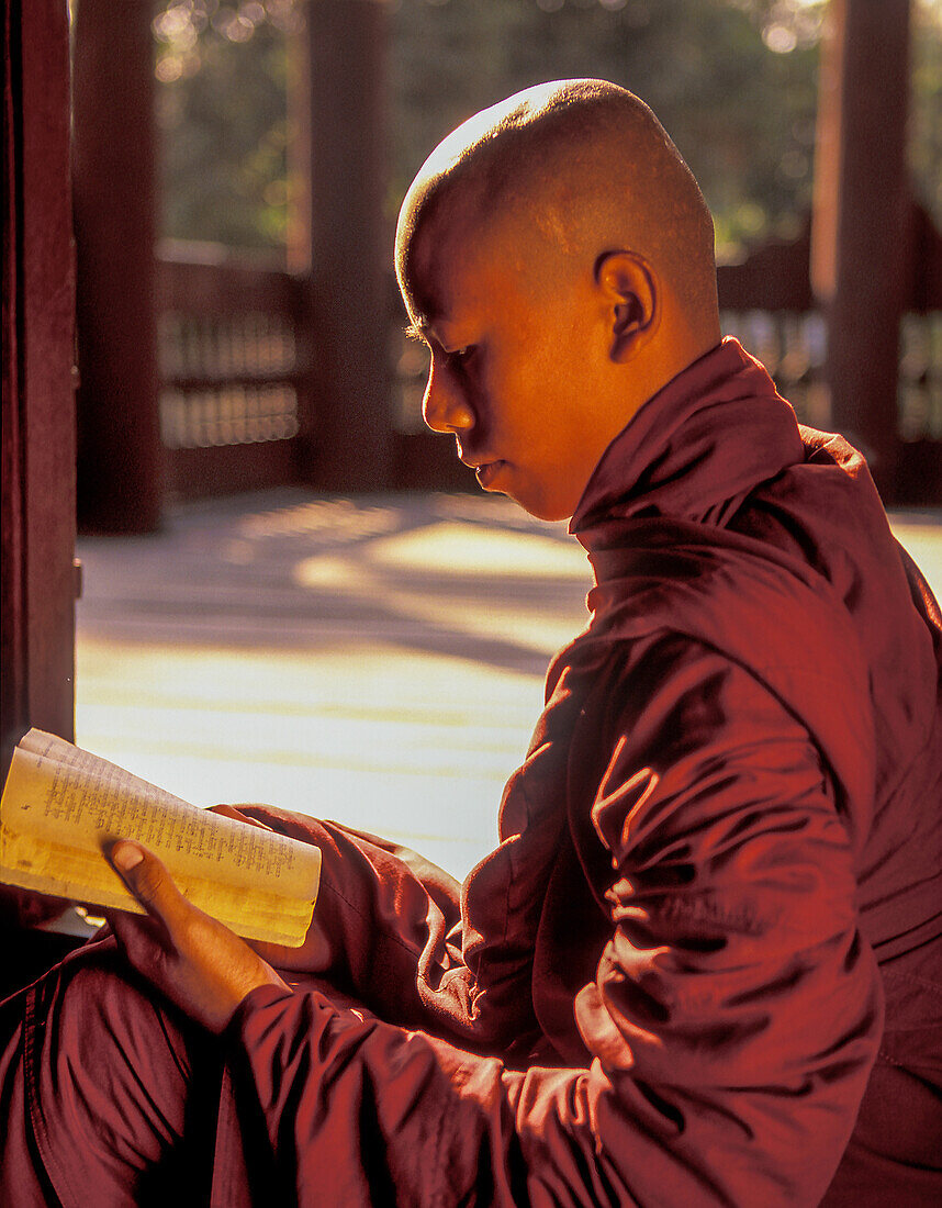 Myanmar, Mandalay, Buddhistischer Mönch liest Gebetsbuch