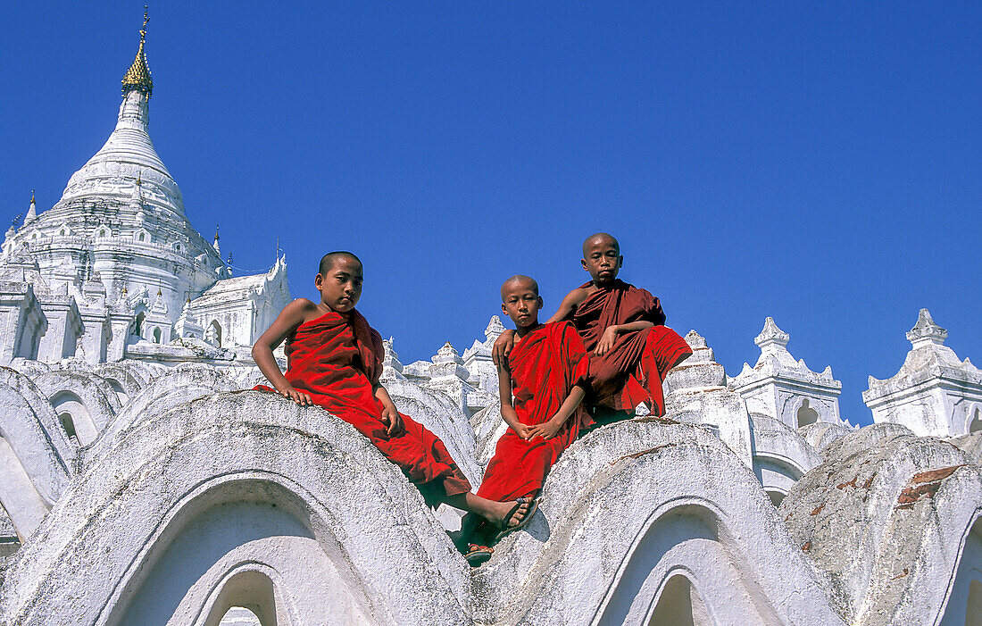 Myanmar, Mingun, Division Mandalay, Buddhistische Mönche sitzen auf den weißen Bögen der Hsinbyume-Pagode