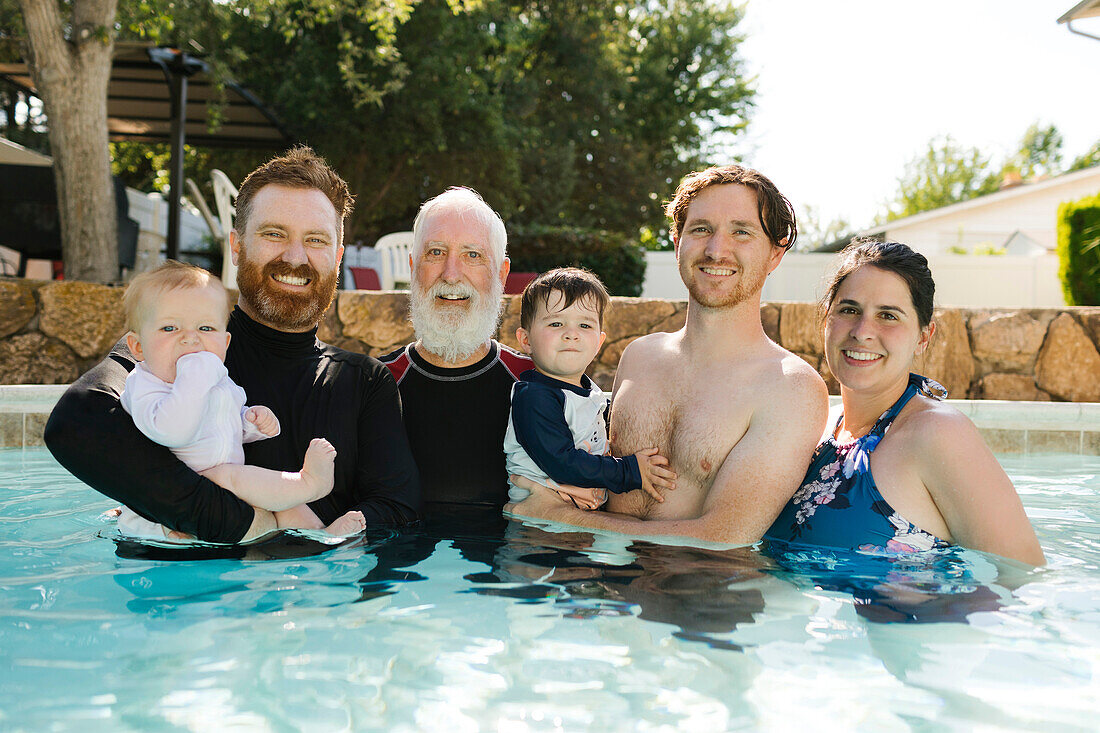 Porträt einer Familie mit Jungen (12-17 Monate, 2-3) im Schwimmbad